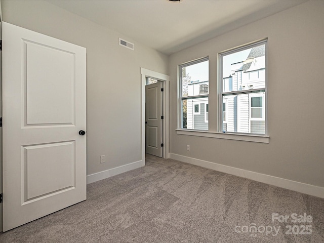 unfurnished bedroom featuring light carpet, baseboards, and visible vents