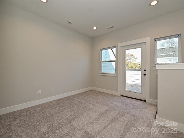 entryway with light carpet, visible vents, a wealth of natural light, and recessed lighting