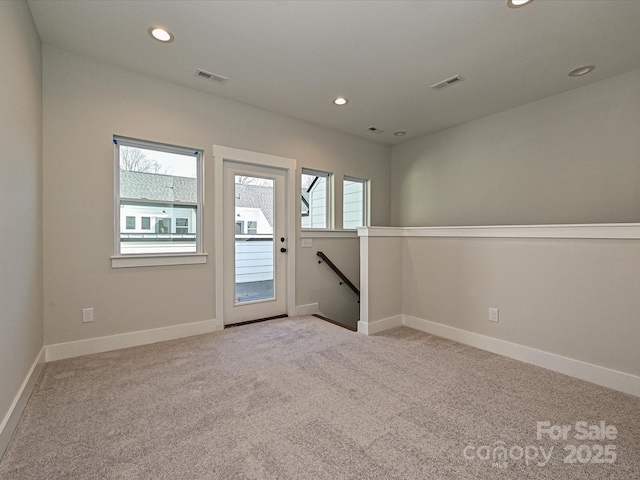 spare room featuring a wealth of natural light, visible vents, light carpet, and recessed lighting