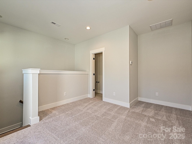 empty room with light colored carpet, visible vents, baseboards, and recessed lighting