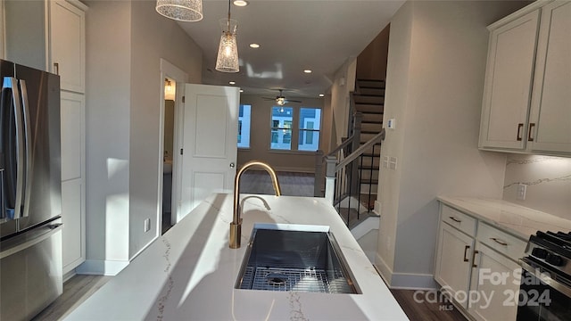 kitchen with white cabinetry, sink, stainless steel appliances, hardwood / wood-style floors, and pendant lighting