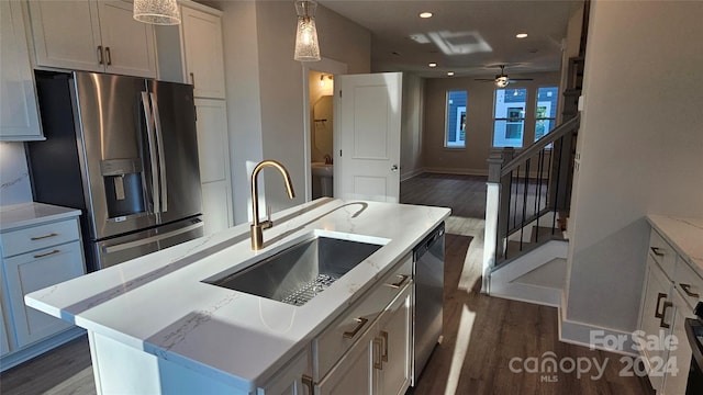 kitchen with a center island with sink, sink, ceiling fan, appliances with stainless steel finishes, and dark hardwood / wood-style flooring