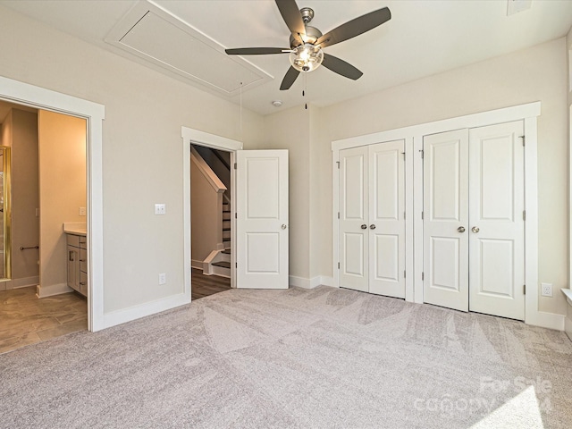 unfurnished bedroom featuring carpet flooring, ceiling fan, connected bathroom, and two closets