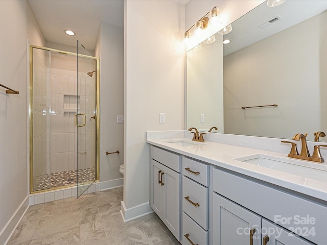 bathroom with a shower with door, vanity, and toilet