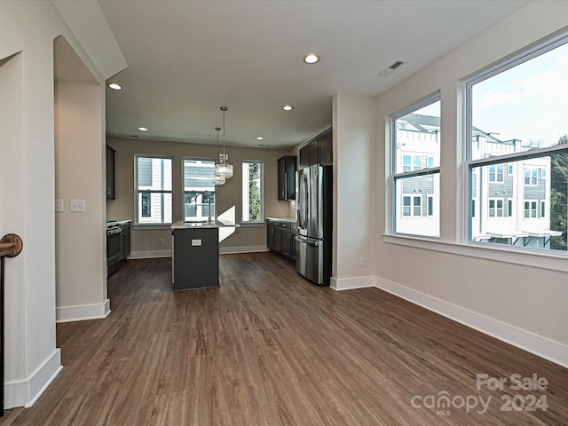 kitchen with a kitchen island with sink, plenty of natural light, stainless steel appliances, and dark hardwood / wood-style floors