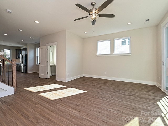 unfurnished living room with ceiling fan and dark wood-type flooring