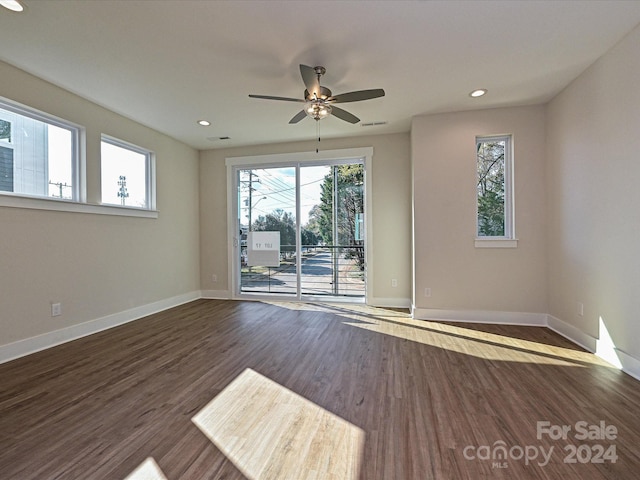 spare room featuring dark hardwood / wood-style flooring, ceiling fan, and plenty of natural light