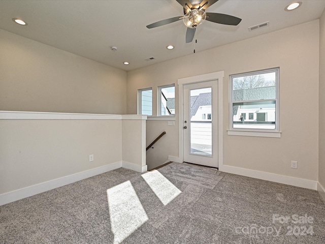 carpeted entrance foyer with a wealth of natural light and ceiling fan