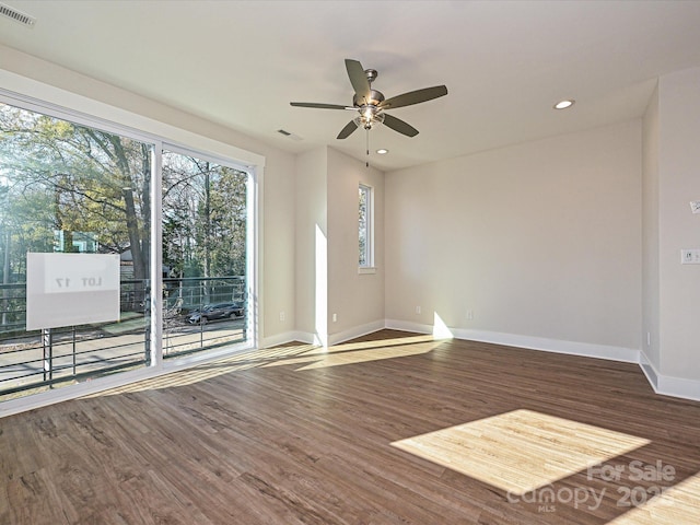 unfurnished room featuring baseboards, wood finished floors, visible vents, and ceiling fan