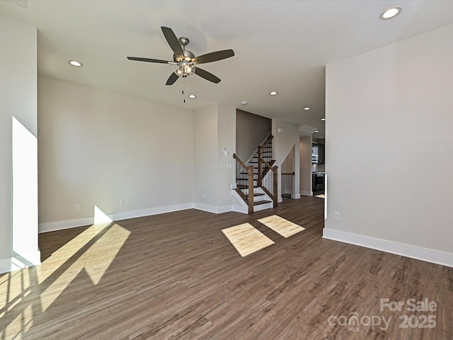 spare room with baseboards, recessed lighting, a ceiling fan, wood finished floors, and stairs
