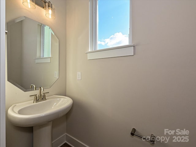bathroom featuring baseboards and a sink