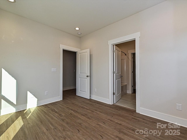 unfurnished bedroom featuring connected bathroom, baseboards, wood finished floors, and recessed lighting