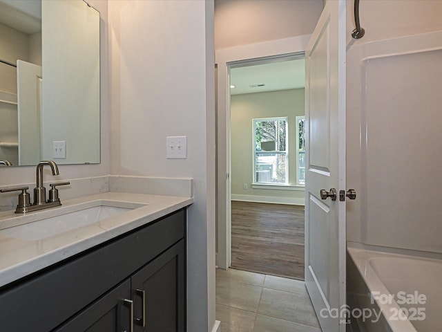 bathroom featuring baseboards, tile patterned flooring, and vanity