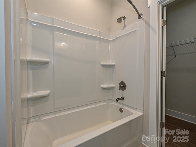 bathroom featuring shower / bath combination, wood finished floors, and baseboards