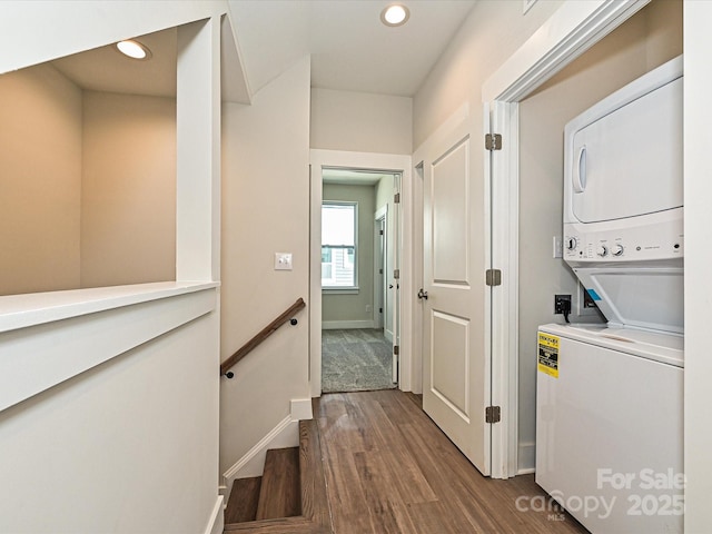 laundry room with recessed lighting, dark wood finished floors, stacked washing maching and dryer, and laundry area