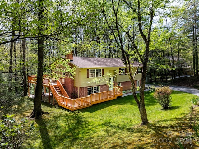 rear view of house with a deck and a lawn