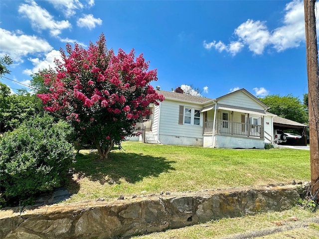 view of front of property with a front yard, a porch, and a carport