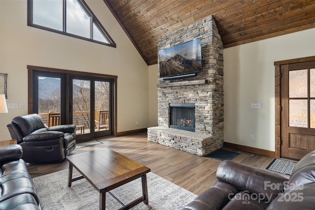 living room featuring a stone fireplace, high vaulted ceiling, wood ceiling, and light wood-type flooring