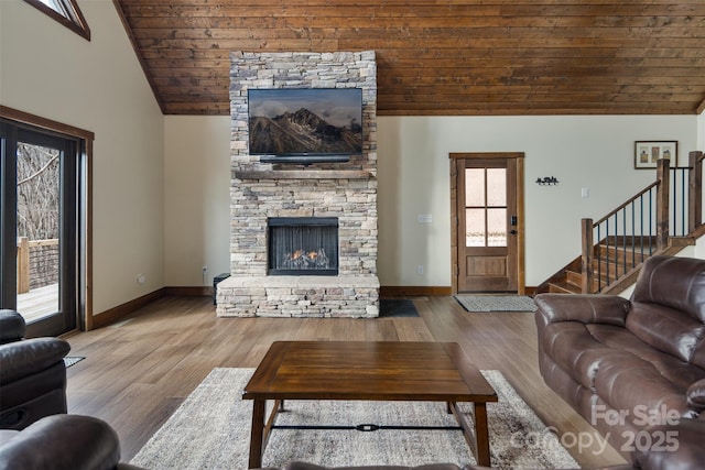 living room with wood ceiling, a fireplace, high vaulted ceiling, and light wood-type flooring