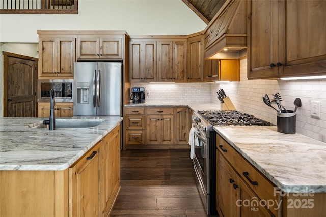 kitchen featuring dark wood-type flooring, sink, light stone counters, tasteful backsplash, and stainless steel appliances