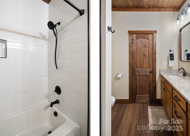 full bathroom featuring wood ceiling, vanity, wood-type flooring, tiled shower / bath, and toilet