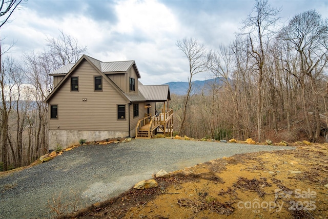 back of house featuring a mountain view and covered porch