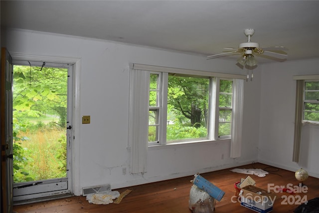 unfurnished living room featuring wood-type flooring, plenty of natural light, and ceiling fan