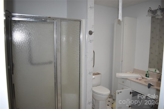 bathroom with tile floors, an enclosed shower, toilet, and vanity