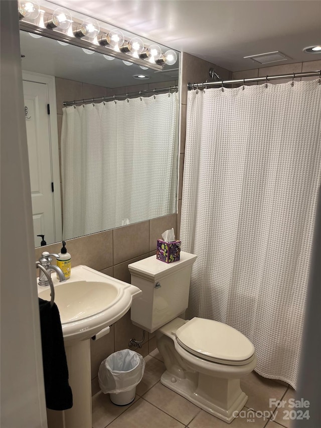 bathroom featuring tile walls, toilet, and tile floors