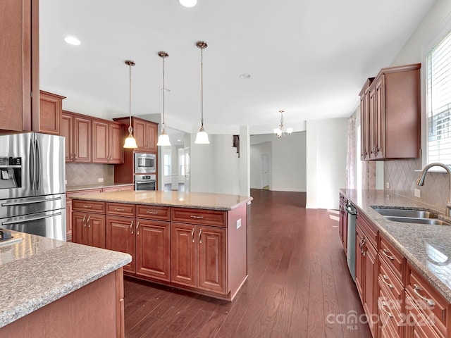 kitchen featuring decorative light fixtures, dark wood-type flooring, backsplash, and appliances with stainless steel finishes