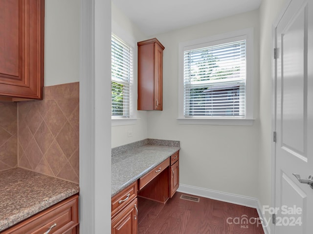 kitchen with light stone counters and dark hardwood / wood-style floors