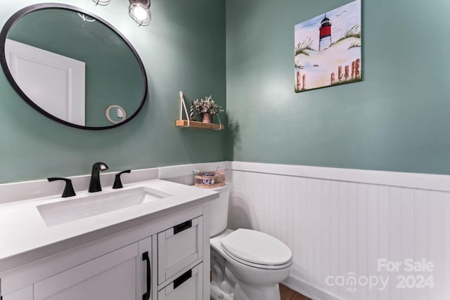 bathroom featuring toilet and vanity with extensive cabinet space