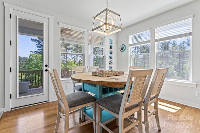 dining area with light wood-type flooring and a chandelier