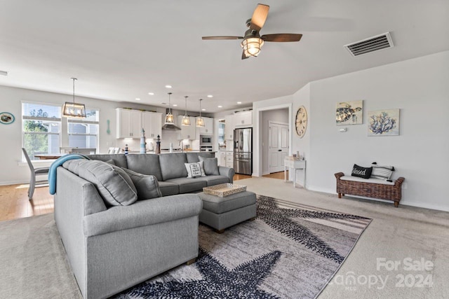 carpeted living room featuring ceiling fan