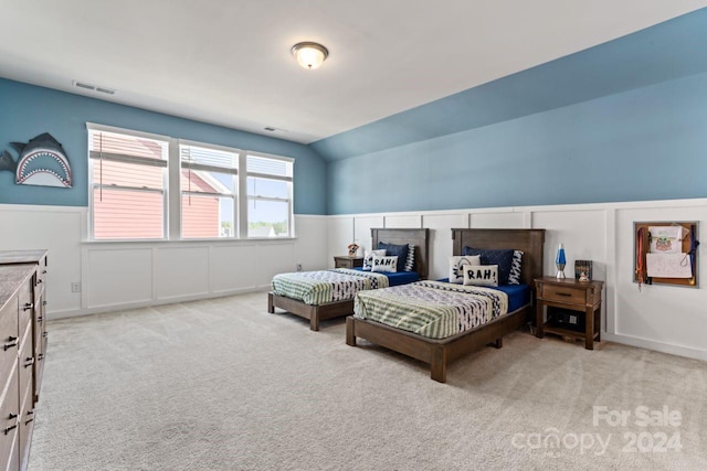 bedroom with lofted ceiling and light colored carpet