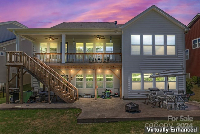 back house at dusk with ceiling fan and a patio