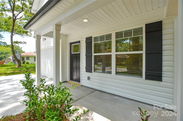 doorway to property featuring covered porch and a garage