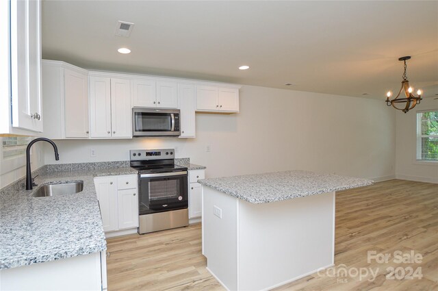 kitchen featuring white cabinets, light hardwood / wood-style flooring, appliances with stainless steel finishes, and a kitchen island