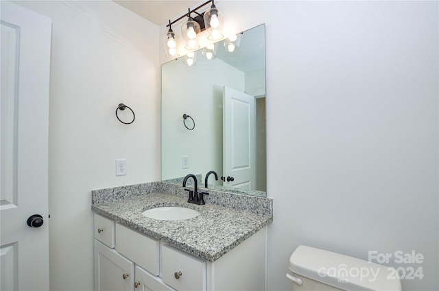 bathroom featuring toilet and vanity