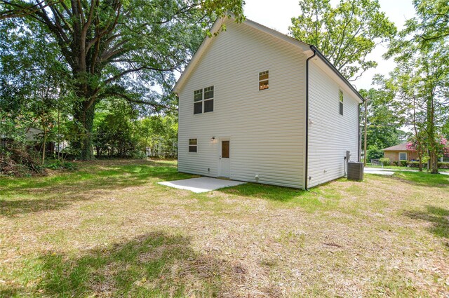 back of house with a patio and a lawn