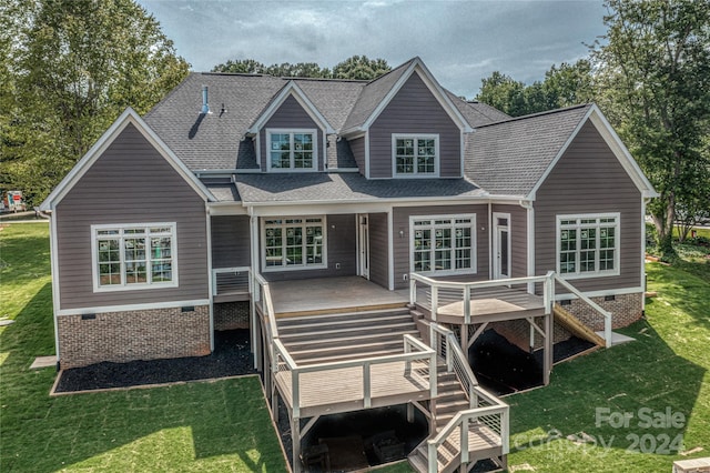 rear view of house featuring a wooden deck and a yard