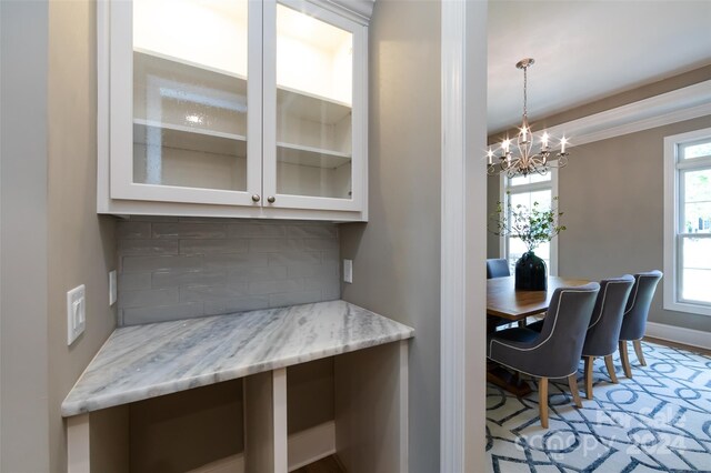 dining space featuring crown molding and a notable chandelier