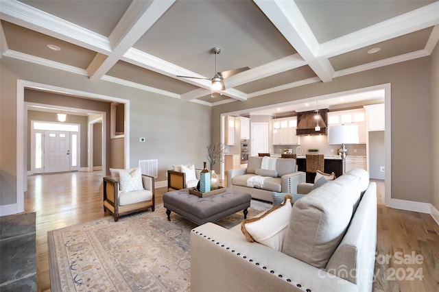 living room with beamed ceiling, crown molding, and coffered ceiling