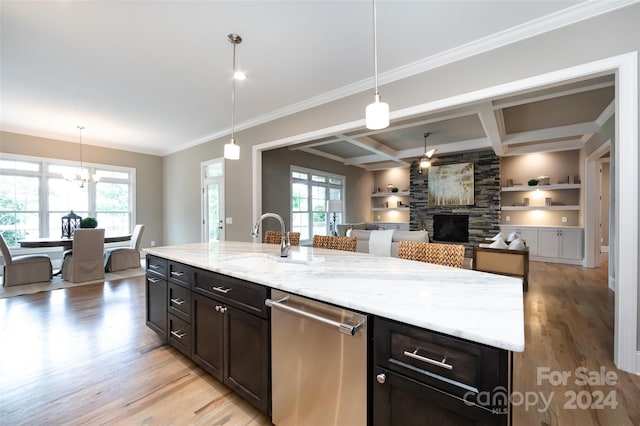 kitchen featuring coffered ceiling, built in features, dishwasher, pendant lighting, and sink