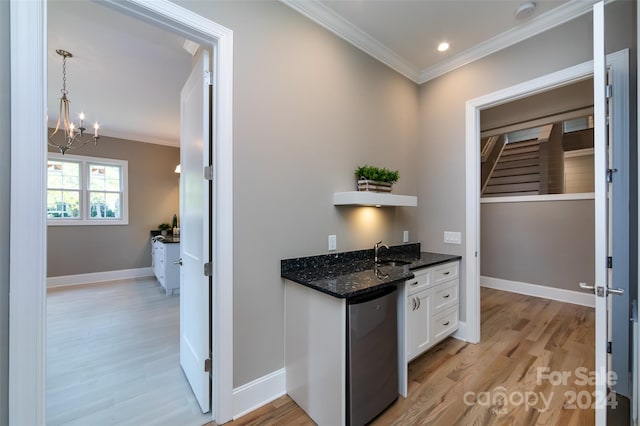 kitchen with dark stone countertops, light hardwood / wood-style floors, dishwasher, and white cabinets