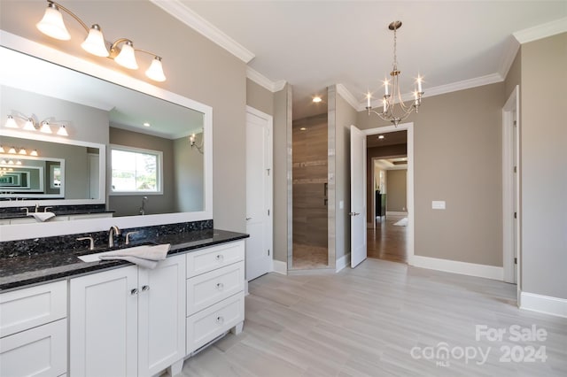 bathroom with vanity, tiled shower, a notable chandelier, and ornamental molding