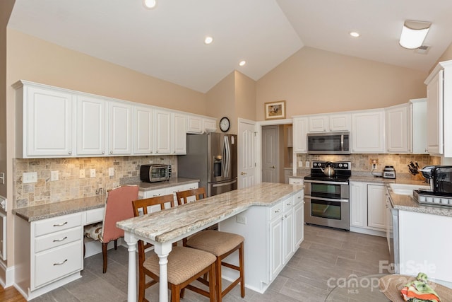 kitchen featuring white cabinets, tasteful backsplash, and stainless steel appliances