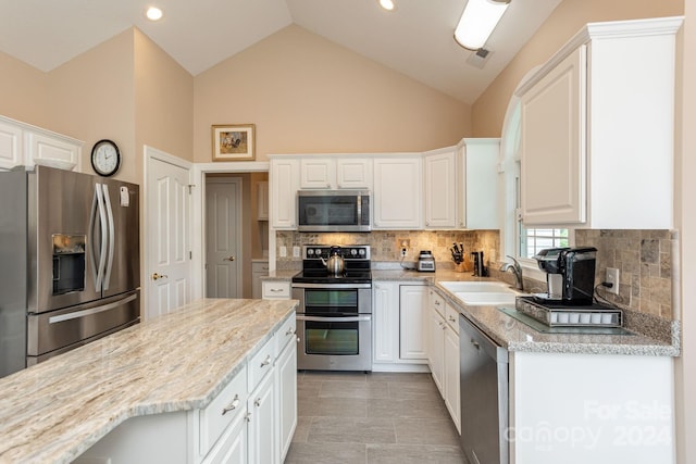 kitchen featuring stainless steel appliances, white cabinets, backsplash, sink, and light tile floors