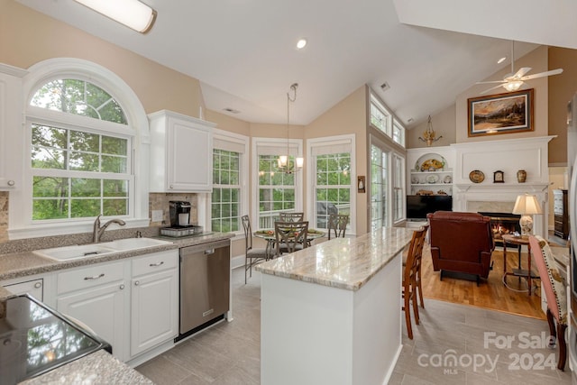 kitchen featuring a fireplace, ceiling fan with notable chandelier, dishwasher, hanging light fixtures, and sink