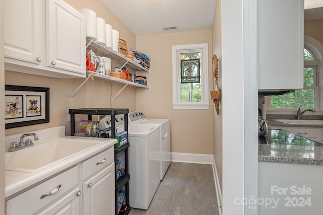 laundry room with washer and clothes dryer, sink, and cabinets